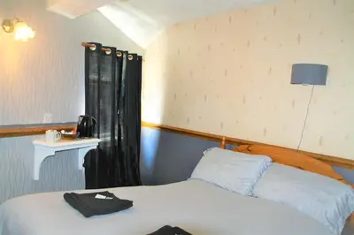 a bedroom with a bed with a black hat on it at Pine Lodge Hotel in Blackpool