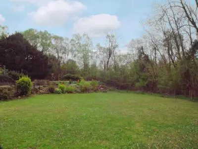 a yard with a large green field with trees at Hope Cottage in Lindale