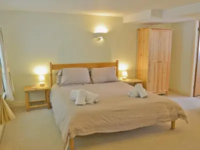 a bedroom with a large bed with towels on it at Hope Cottage in Lindale