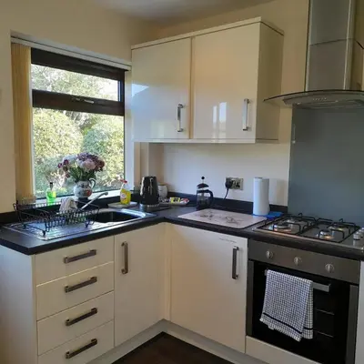a kitchen with white cabinets and a stove top oven at Kents Bank Holiday - Pet Friendly with Bay Views in Grange Over Sands