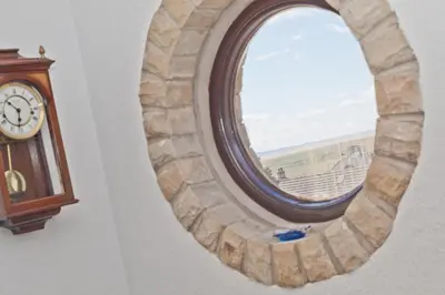 a round window in a wall with a clock at Kents Bank Holiday - Pet Friendly with Bay Views in Grange Over Sands