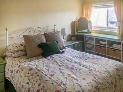 a bedroom with a bed with pillows and a window at Harbour Cottage in Millom