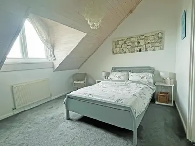 a bedroom with a bed in a attic at Cockleshell Cottage in Millom