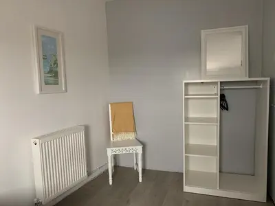 a chair sitting in a room with a white wall at Cockleshell Cottage in Millom