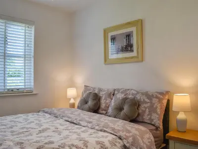 a bedroom with a bed and a couch and two lamps at Cosy Cottage in Holker