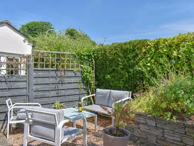 two chairs and a table in a garden at Cosy Cottage in Holker