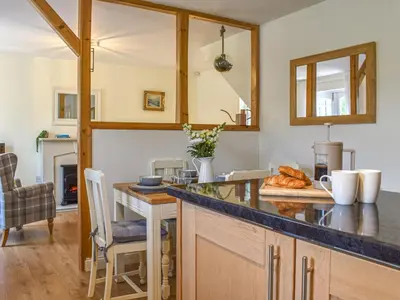 a kitchen with a counter and a table with bread at Cosy Cottage in Holker