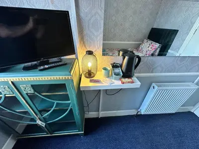 a desk with a tv and a table with a television at B&B Runway Blackpool - Minutes From Winter Gardens - Dog Friendly - Exceptionally Quiet - Very Close H&A Social Club in Blackpool
