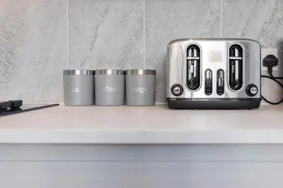 a toaster and four cups sitting on a counter at Flatzy - 16 Guests 4 En-suite Central Apartment A in Liverpool