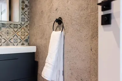 a white towel hanging on a wall in a bathroom at Flatzy - 16 Guests 4 En-suite Central Apartment A in Liverpool