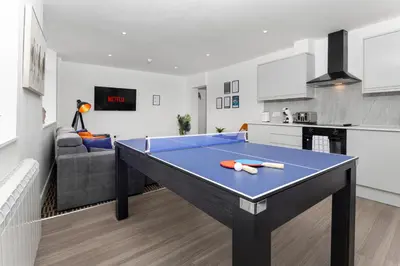 a blue ping pong table in a living room at Flatzy - 16 Guests 4 En-suite Central Apartment A in Liverpool