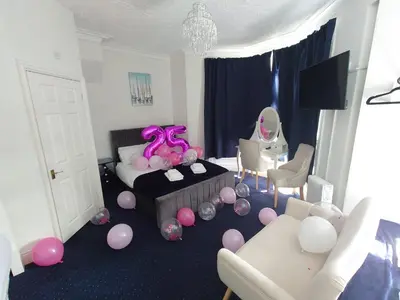 a room with pink and purple balloons and a bed at Harriette's Guest House in Blackpool