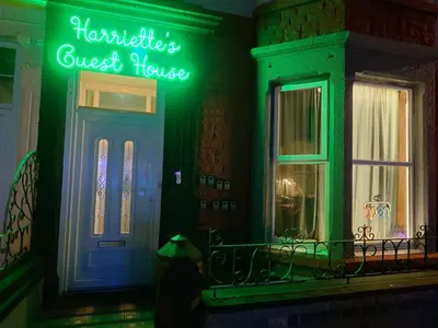 a front door of a house with a neon sign on it at Harriette's Guest House in Blackpool