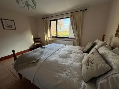 a bedroom with a large white bed with a window at Rural Family Farmhouse with Countryside views in Southport