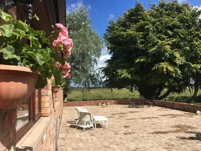 a patio with two chairs and a tree at Rural Family Farmhouse with Countryside views in Southport