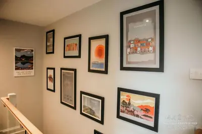 a wall with framed pictures on a wall at Princes st by Prestige Properties SA in Ulverston
