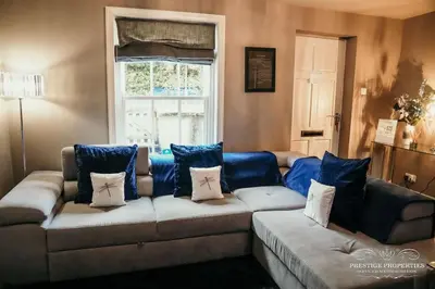 a living room with a couch and a window at Princes st by Prestige Properties SA in Ulverston