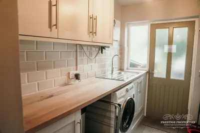 a kitchen with a sink and a washing machine at Princes st by Prestige Properties SA in Ulverston