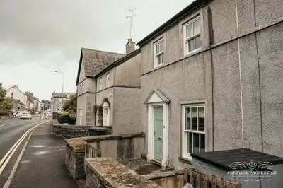 an old building with a green door on a street at Princes st by Prestige Properties SA in Ulverston