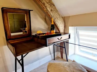 a dressing table with a mirror and a bottle of wine at The Cruck in Preston