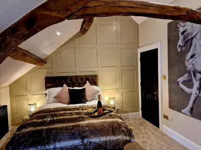 a bedroom with a bed with a horse painting on the wall at The Cruck in Preston