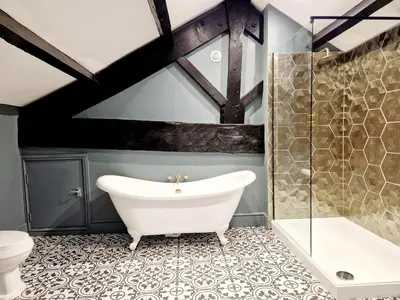 a bathroom with a white bath tub and a toilet at The Cruck in Preston