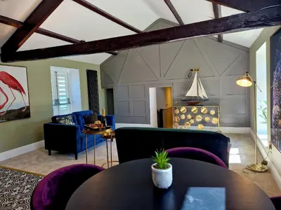 a living room with purple chairs and a table at The Cruck in Preston