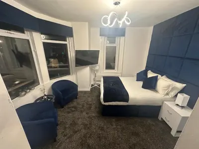 a hotel room with a bed and two windows at Luxe Hotel Blackpool in Blackpool