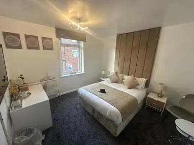 a bedroom with a large bed and a window at Luxe Hotel Blackpool in Blackpool