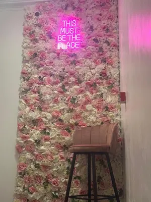 a wall covered in roses with a stool in front of it at Luxe Hotel Blackpool in Blackpool