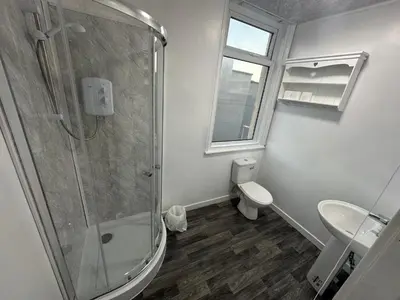 a bathroom with a shower and a toilet and a sink at Luxe Hotel Blackpool in Blackpool