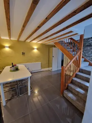 a living room with a staircase and a table at Courtyard Cottage in Cartmel