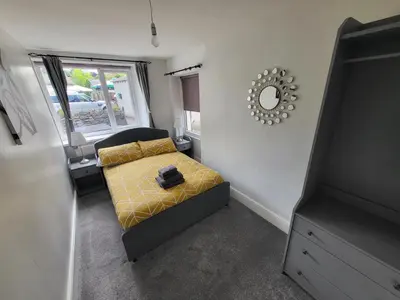 a small bedroom with a bed and a mirror at Courtyard Cottage in Cartmel