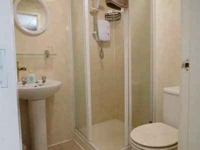a bathroom with a shower with a toilet and a sink at Bianca Guesthouse in Blackpool