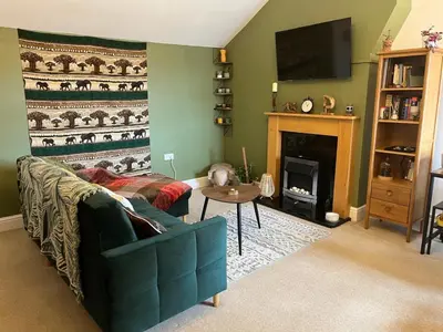 a living room with a blue couch and a fireplace at Cosy & Calm Escape by the Sea in Lytham St Annes