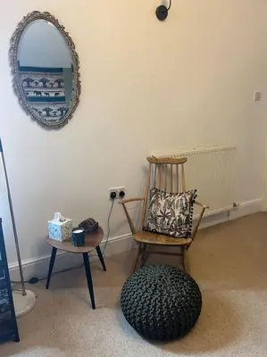 a room with a chair and a mirror on the wall at Cosy & Calm Escape by the Sea in Lytham St Annes