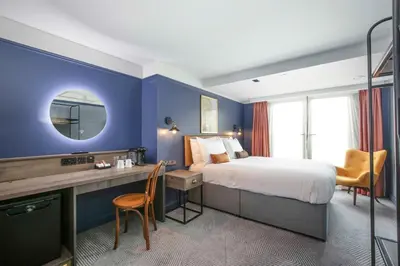 a bedroom with a bed and a desk with a mirror at Ropewalks Hotel in Liverpool