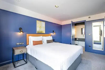 a bedroom with a large bed with blue walls at Ropewalks Hotel in Liverpool