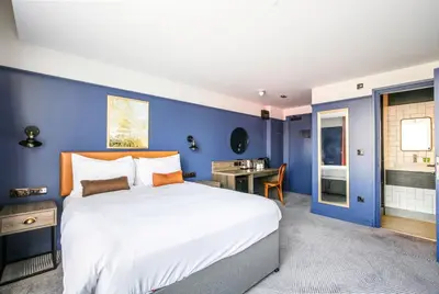 a bedroom with a large bed and a blue wall at Ropewalks Hotel in Liverpool