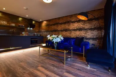 a living room with a blue couch and a table at Wayside Lodge in Blackpool
