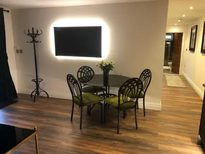 a dining room with a table and chairs and a television at Wayside Lodge in Blackpool
