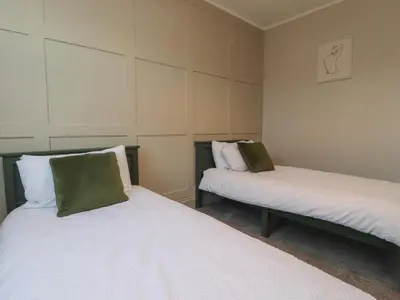 two beds sitting in a room withermottermottermott at Homewood in Preston