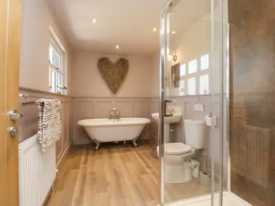 a bathroom with a tub and a toilet and a sink at Homewood in Preston