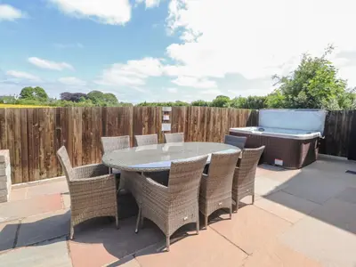 a patio with a table and chairs and a barbecue at Homewood in Preston