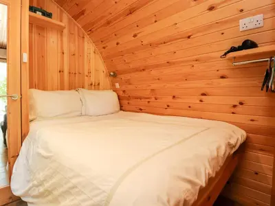 a bedroom with a bed in a wooden wall at Homewood Pod in Preston