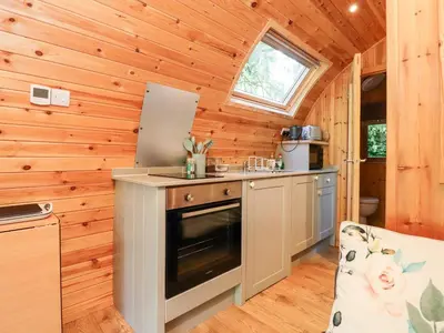 a kitchen in a tiny house with wooden walls at Homewood Pod in Preston