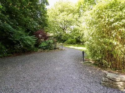a gravel road in a park with trees and bushes at Homewood Pod in Preston