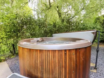a jacuzzi tub in a garden with trees at Homewood Pod in Preston