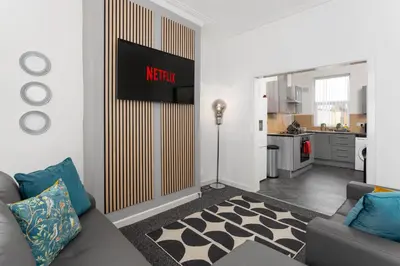 a living room with a couch and a kitchen at Woodbine House - Air Host and Stay - Free parking - Contractor Friendly in Liverpool