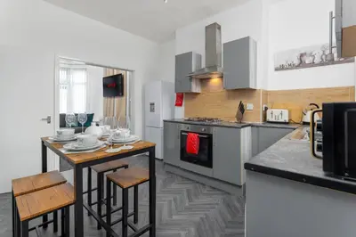 a kitchen with a counter and a table with chairs at Woodbine House - Air Host and Stay - Free parking - Contractor Friendly in Liverpool